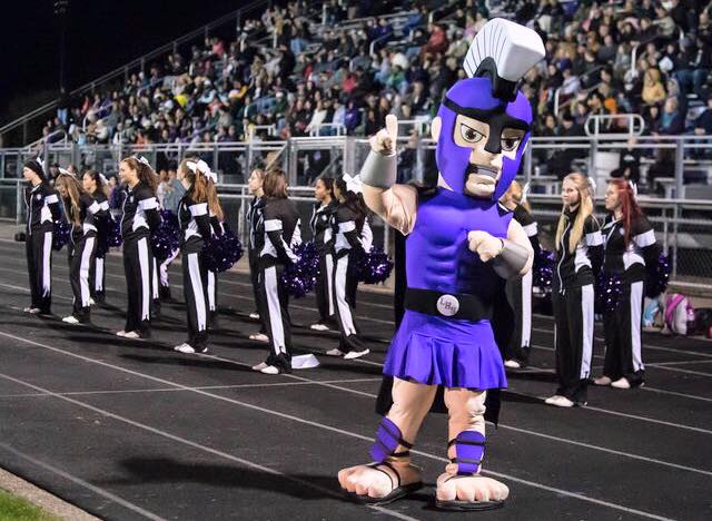 Lakeview-High-School-Spartan-mascot Custom spartan mascot costume in from of cheerleader group at a sports event.