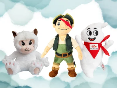 Three plush toys: a pirate figure between a white fluffy cat and a white ghost-like character with a red scarf, set against a cloudy blue background.